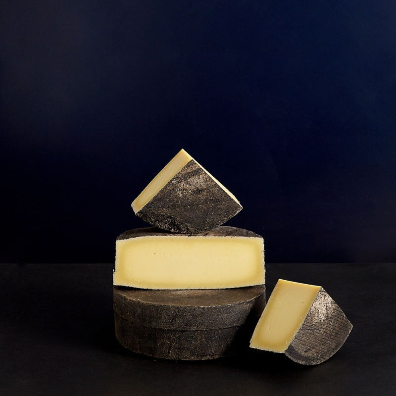 A tower of Cornish Kern, showing the dramatically dark rind and dense paste