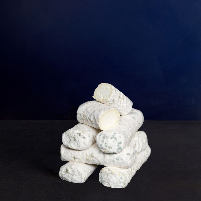 Small tower of whole and cut log-shaped Ragstone goat’s milk cheeses with a white mould-covered, smooth rind and dense paste