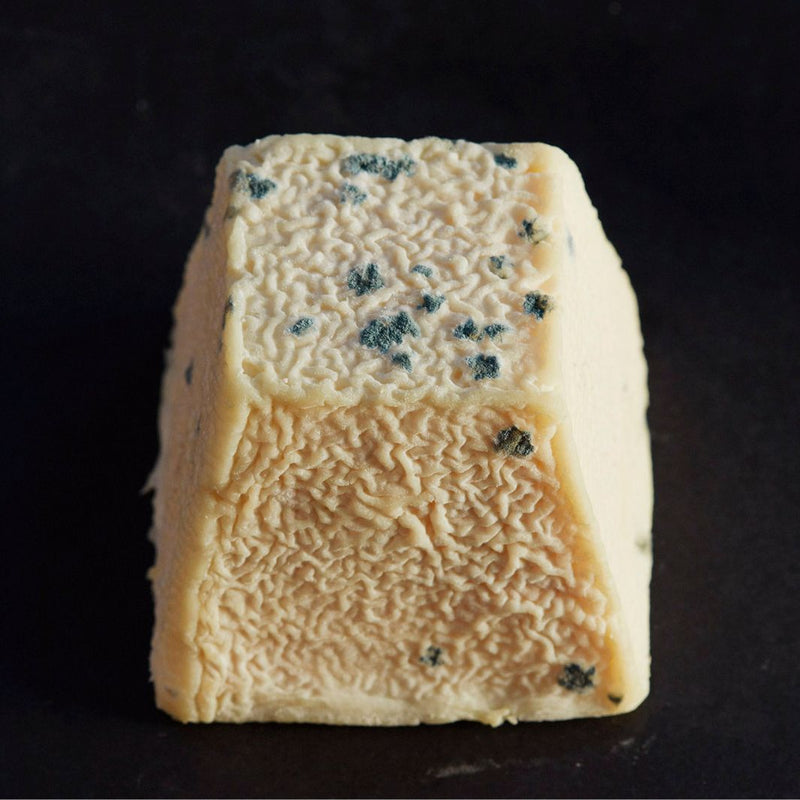 Whole Sinodun Hill goat’s cheese, with a golden-coloured, mould-flecked, wrinkly rind.