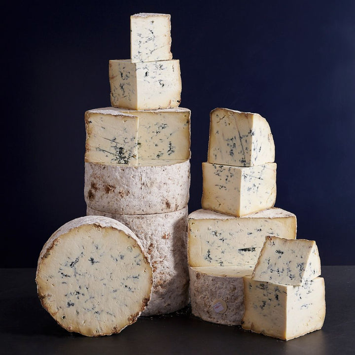 Towers of smaller and larger cuts, and a whole Stichelton cheese with blue veining and a soft creamy paste