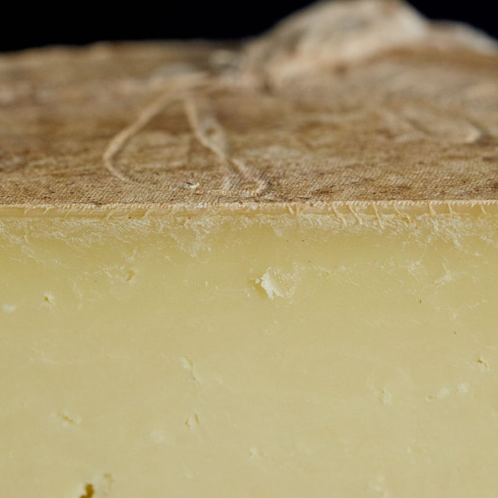 Close up of a cut piece of clothbound Corra Linn sheep’s milk cheese with creamy, succulent paste